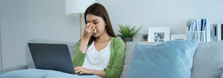 A woman holding her forehead.